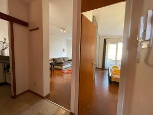 a hallway of a living room with a couch and a door at Locarno: Casa Lido in Locarno