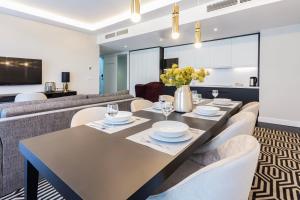 a dining room with a table and chairs and a couch at VacationClub - Baltic Park Fort Apartament G.507 in Świnoujście