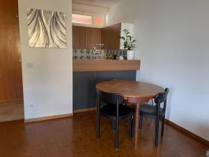 a small kitchen with a wooden table and black chairs at Locarno: Casa Lido in Locarno