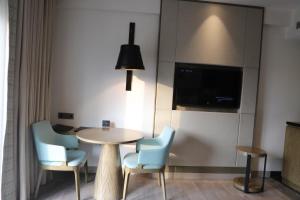 a room with a table and chairs and a tv at THE CRUZE PREMIUM BOUTIQUE HOTEL in Jamshedpur