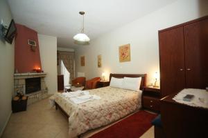 ein Schlafzimmer mit einem großen Bett und einem Kamin in der Unterkunft Orama Hotel - Serene Lake Plastira Retreat with Stunning Views in Kryonérion