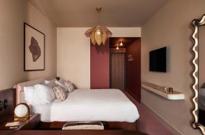 a bedroom with a white bed and a tv at The Hoxton, Brussels in Brussels