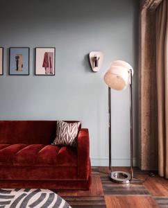 a living room with a red couch and a lamp at The Hoxton, Brussels in Brussels