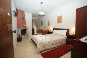 um quarto com uma cama e uma lareira em Hotel Orama em Kryonérion