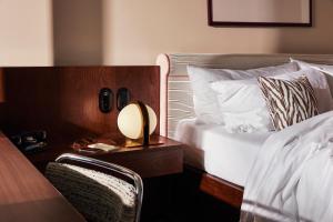 a bedroom with a bed and a table with a lamp at The Hoxton, Brussels in Brussels