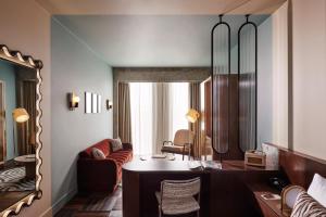 a living room with a desk and a mirror at The Hoxton, Brussels in Brussels