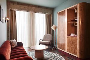 a living room with a couch and a table at The Hoxton, Brussels in Brussels