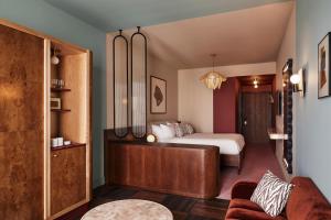 a bedroom with a bed and a couch at The Hoxton, Brussels in Brussels