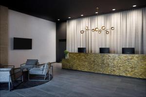 a lobby with a reception desk and chairs at Travelodge Hotel Auckland Wynyard Quarter in Auckland