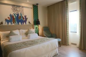 a bedroom with a bed with a painting on the wall at THE CRUZE PREMIUM BOUTIQUE HOTEL in Jamshedpur