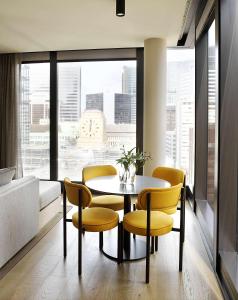 a dining room with a table and chairs and a large window at A by Adina Sydney in Sydney