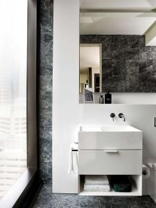 a bathroom with a white sink and a mirror at A by Adina Sydney in Sydney