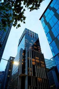 a tall glass building in a city at A by Adina Sydney in Sydney