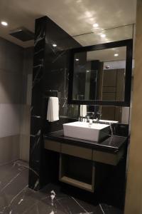 a bathroom with a white sink and a mirror at THE CRUZE PREMIUM BOUTIQUE HOTEL in Jamshedpur +18 photos