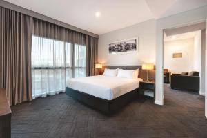 um quarto de hotel com uma cama e um sofá em Vibe Hotel Subiaco Perth em Perth