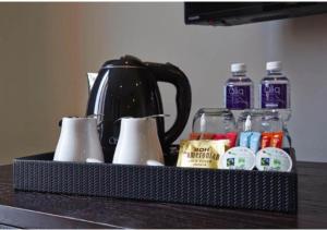 a black tray with a tea kettle and other items on a counter at Hotel Damansara Perdana - Q in Petaling Jaya