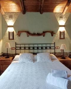 a bedroom with a large white bed with two pillows at La Cabana´l Cachican in Cangas del Narcea