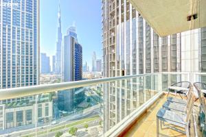 a balcony with a chair and a view of the city at bnbmehomes - 2BR Apt with Burj Khalifa View -1406 in Dubai