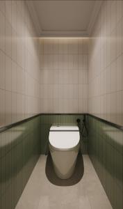 a bathroom with a toilet in a green and white tiled wall at Hangzhou Lighting Lanshan Youth Hostel in Hangzhou