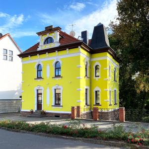 a yellow house with a clock tower on top at Zitronenhaus in Bad Frankenhausen