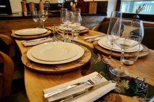 a wooden table with plates and wine glasses on it at Apartment-Chalet Panorama in Todtmoos