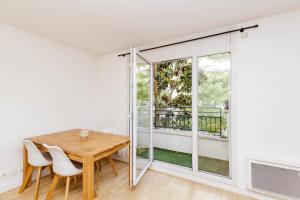 a dining room with a table and chairs and a balcony at Large apartment near Bois de Vincennes in Charenton-le-Pont