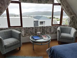 1 Schlafzimmer mit 2 Stühlen, einem Tisch und einem Fenster in der Unterkunft Yellowwood Lodge in Knysna