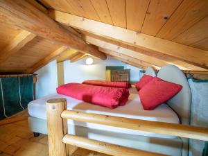 um quarto com uma cama com almofadas vermelhas em Bait da Sandro em Livigno