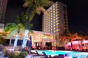 um hotel com piscina em frente a um edifício em Guam Reef Hotel em Tumon