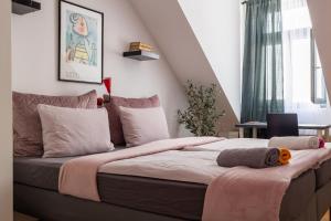 um quarto com uma cama grande e um cobertor rosa em Cukrarna Guest Accommodation em Kranj