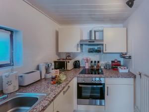 a kitchen with white cabinets and a sink at Ferienhaus Costa Kiesa in Schwarmstedt