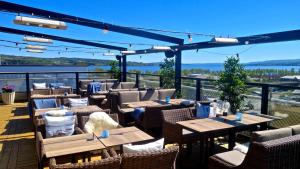 un restaurant avec des tables et des chaises sur une terrasse dans l'établissement Quality Hotel Strand Gjøvik, à Gjøvik