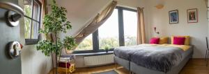 a bedroom with a bed and a large window at Cukrarna Guest Accommodation in Kranj