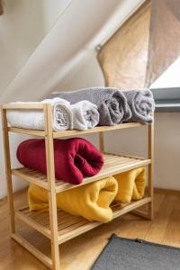 a wooden towel rack with towels and towels at Cukrarna Guest Accommodation in Kranj