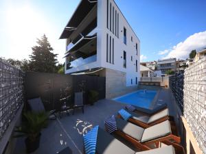 a balcony with a swimming pool and a house at AdAstra Apartments in Maslenica