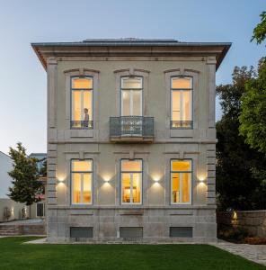 Casa de piedra grande con ventanas y balcón. en Casa Kala en Oporto