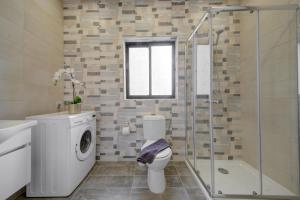 een badkamer met een toilet en een glazen douche bij Fleur Court - Sliema 4 Bedroom Side Seaviews Apartments And Penthouse By ShortLetsMalta in Sliema
