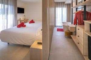 una camera da letto con un letto con cuscini rossi di Hotel Alhambra a Santa Susanna