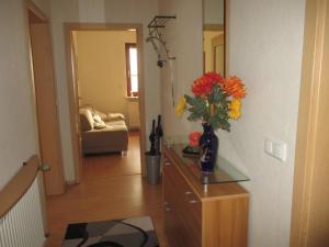 ein Wohnzimmer mit einer Blumenvase auf der Kommode in der Unterkunft Ferienwohnung Leipold Andreas in Merzig