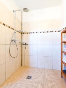 y baño con ducha de azulejos blancos. en Ferienwohnung Leipold Andreas, en Merzig