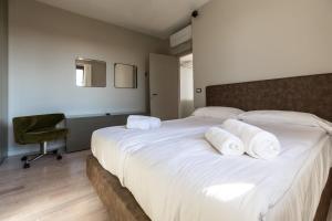a bedroom with a large white bed with towels on it at Casa Veronica in Manerba del Garda +37 photos