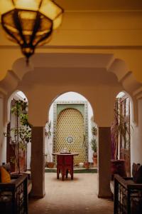 - un hall avec une table et un lustre dans l'établissement Outsite Marrakesh, à Marrakech