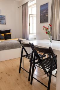 a room with a desk and a bed with a table and chairs at Cukrarna Guest Accommodation in Kranj