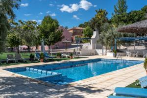 a swimming pool in a yard with chairs and trees at Rapia. Casa Azul 6 in Los Granadicos