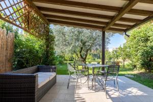 un patio con mesa y sillas bajo una pérgola en Residence Il Melograno en Manerba del Garda