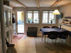 une salle à manger avec une table bleue et des chaises dans l'établissement Dejligt lille byhus, à Fåborg