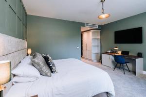 a bedroom with a large white bed and a desk at Edenmore House in Craigavon