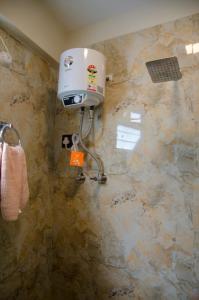 a bathroom with a water heater on a wall at The Brick House Stay in Kalimpong