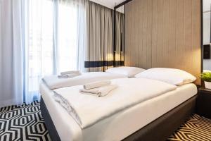 a bedroom with two beds with white sheets at VacationClub - Baltic Park Fort Apartament G.508 in Świnoujście