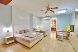 a bedroom with a bed and a ceiling fan at 97 Merryland Apartments & Hotel in Ban Bang Samak +19 photos